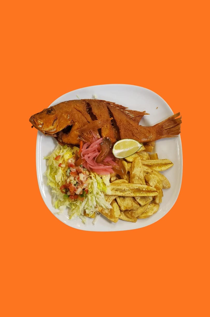 A whole fried fish with plantain fries, shredded lettuce, pico de gallo, and pickled onions.